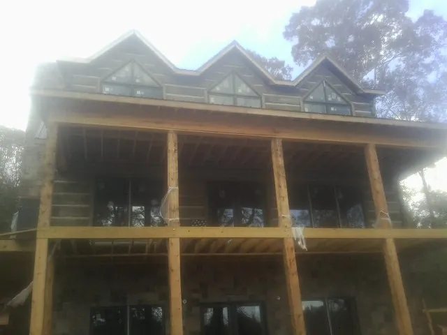 Dormers and porch framing on a large log home under construction — Roof Coating work by our crew in Tell City