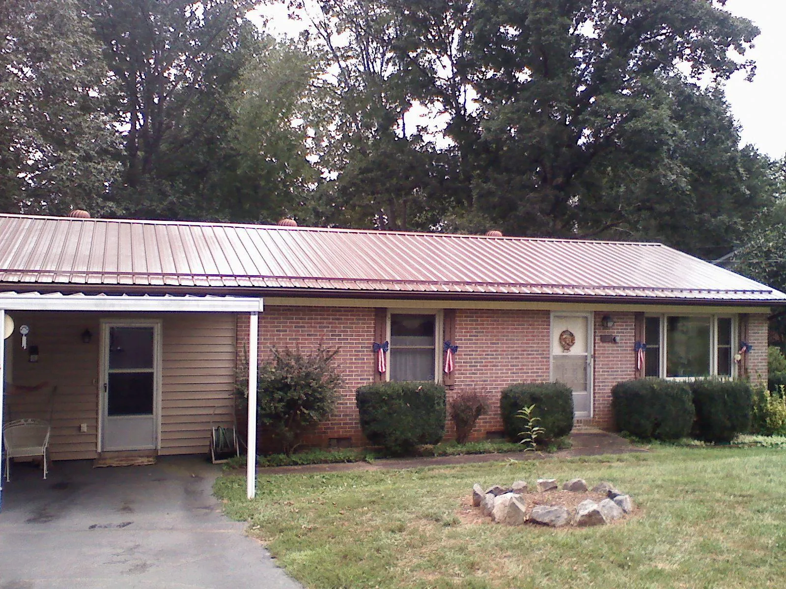 Bronze metal roof and carport on a brick ranch home — Roof Repair work by our crew in Tell City