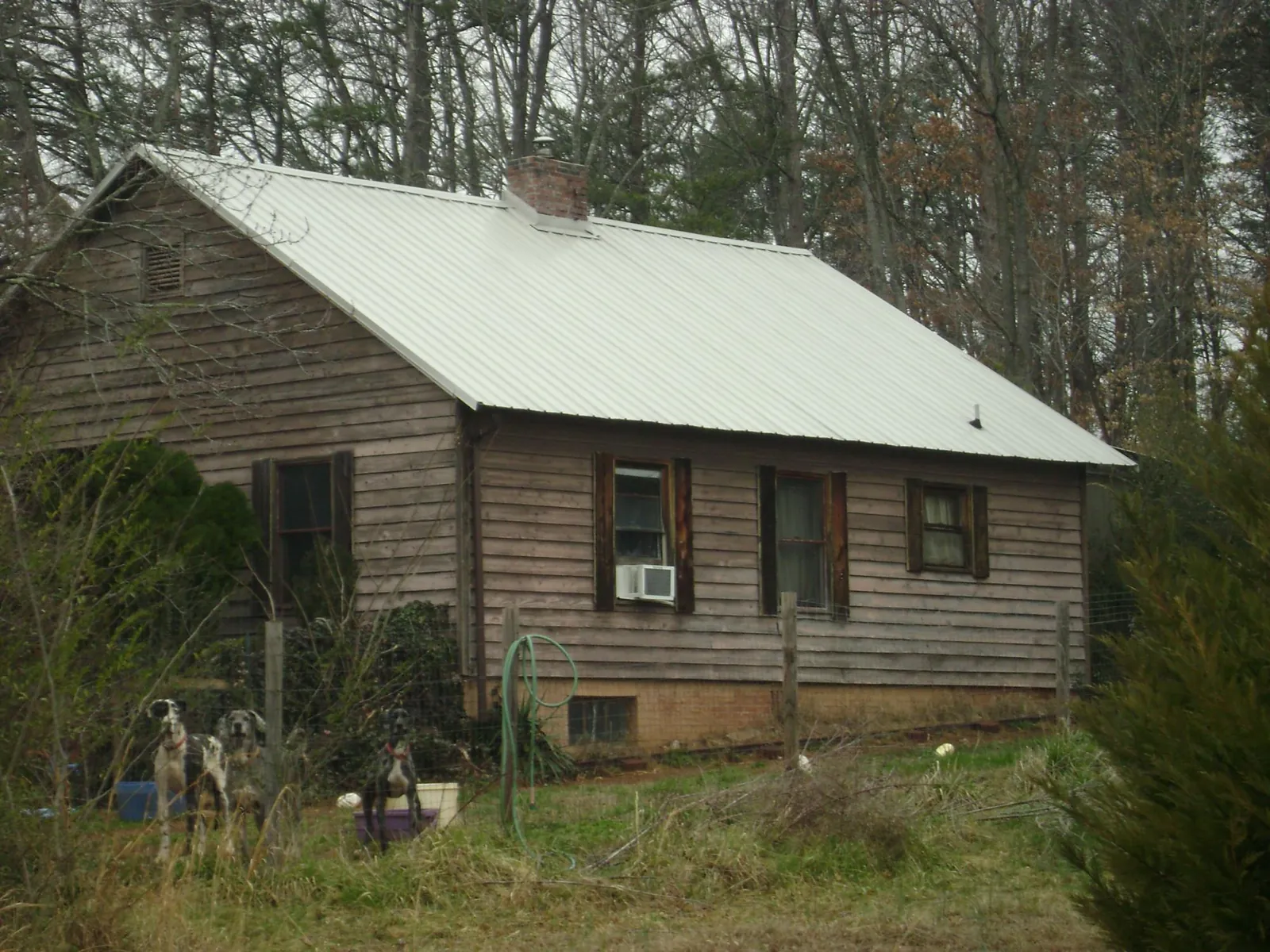White metal roof on an old wood sided farmhouse, from a Metal Roof Installation job in Tell City